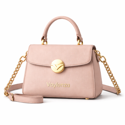 Pink handbag with gold chain and handle on a white background, featuring the brand 'Vaylenza'.